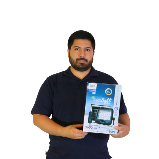 Felipe con caja del Proyector solar LED SenseLight 150W marca LOGIC con panel solar y control remoto, ideal para iluminación exterior en patios, jardines y accesos.