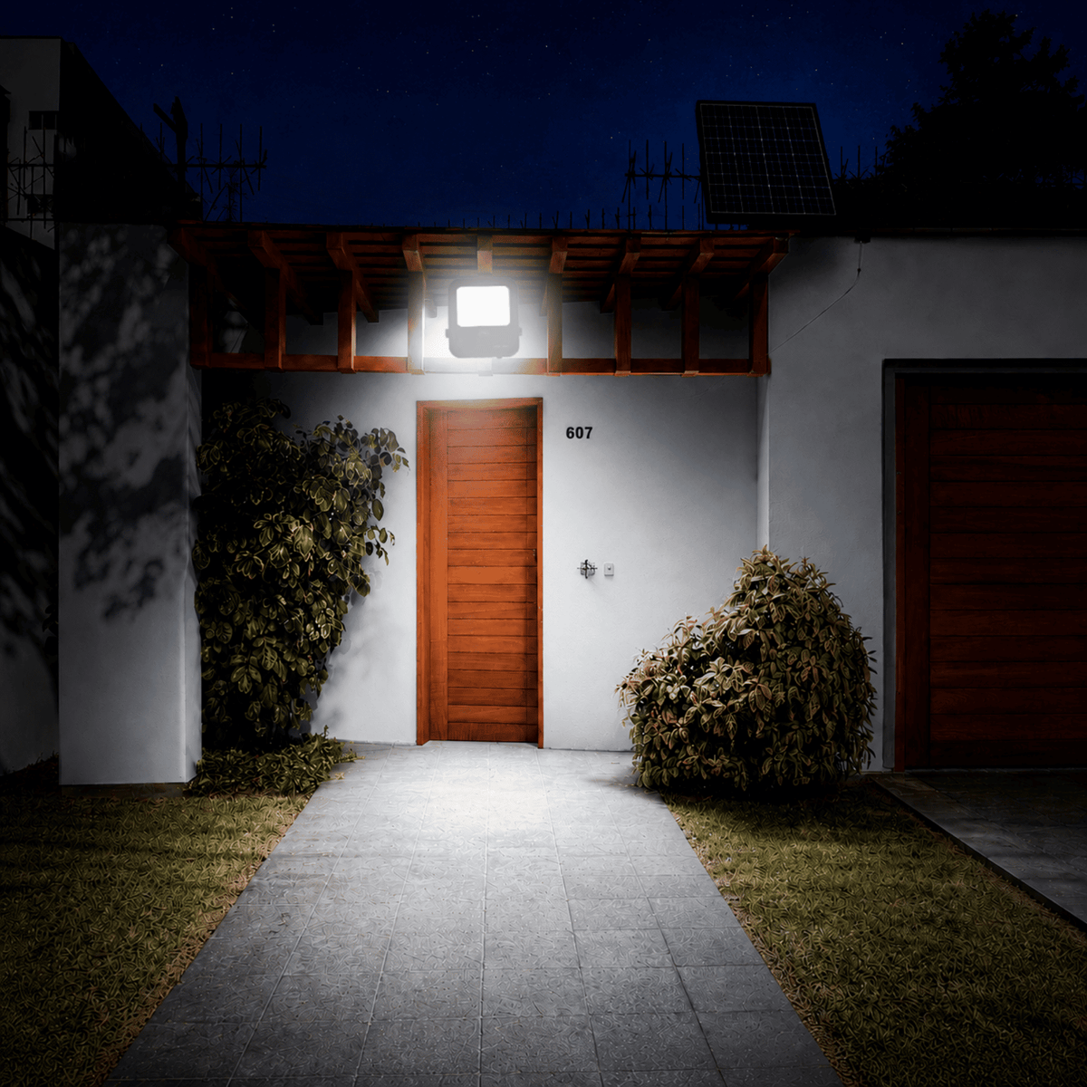 Proyector Solar LED SOL Light 150W iluminando el frontis de una casa con luz fría y energía solar.